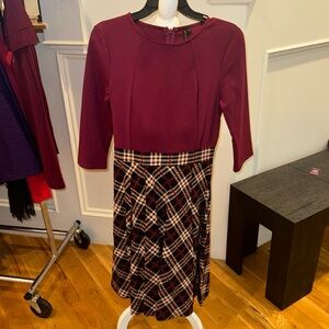 Maroon top fitted with plaid skirt.
